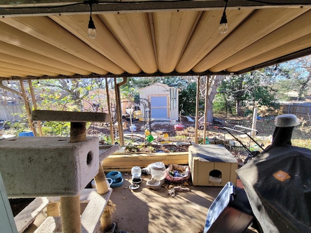 wooden deck featuring area for grilling and a storage shed