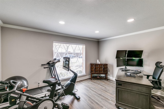 workout area with a textured ceiling, light hardwood / wood-style flooring, and crown molding