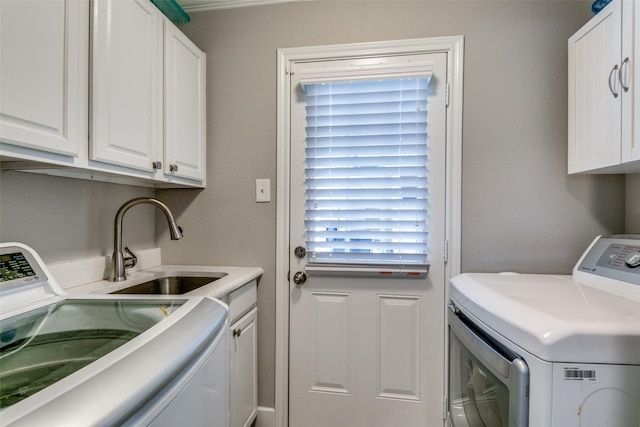 laundry area with washer and dryer, sink, a wealth of natural light, and cabinets