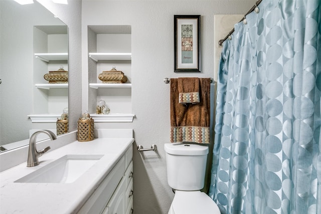 bathroom featuring toilet, curtained shower, and vanity