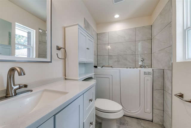 bathroom with toilet, washer / clothes dryer, and vanity