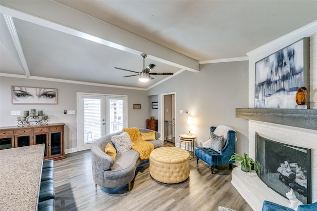 living room with french doors, hardwood / wood-style floors, a fireplace, and lofted ceiling with beams