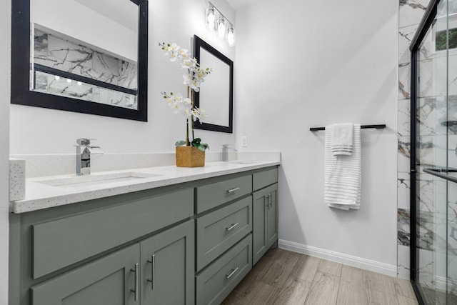 bathroom with hardwood / wood-style flooring, vanity, and a shower with door