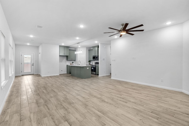 unfurnished living room with ceiling fan and light wood-type flooring