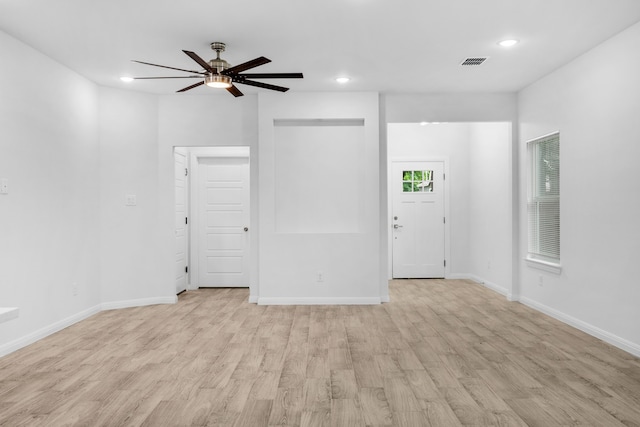 empty room with ceiling fan and light hardwood / wood-style flooring