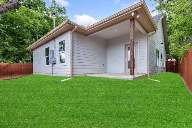 rear view of house featuring a yard and a patio area