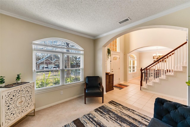 living area featuring tile patterned flooring, a chandelier, a textured ceiling, and ornamental molding