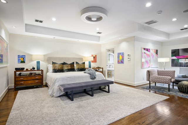 bedroom featuring a tray ceiling and dark wood-type flooring