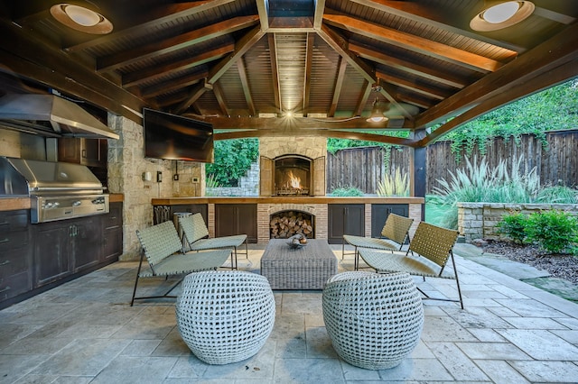 view of patio / terrace with an outdoor stone fireplace, grilling area, and a gazebo