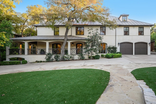 view of front of house with a porch, a garage, and a front yard