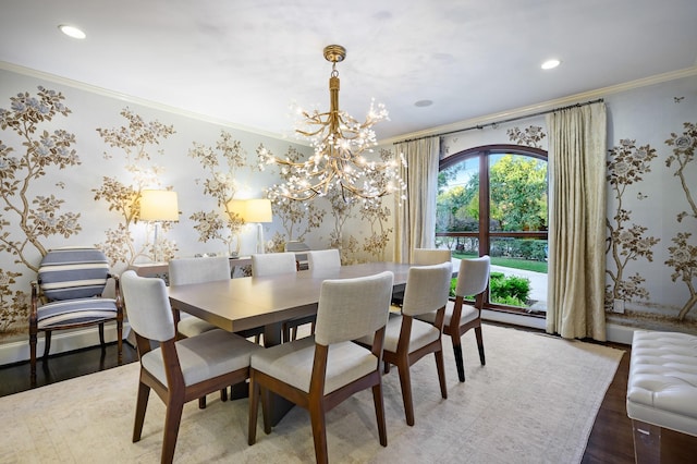 unfurnished dining area with hardwood / wood-style flooring, crown molding, and an inviting chandelier