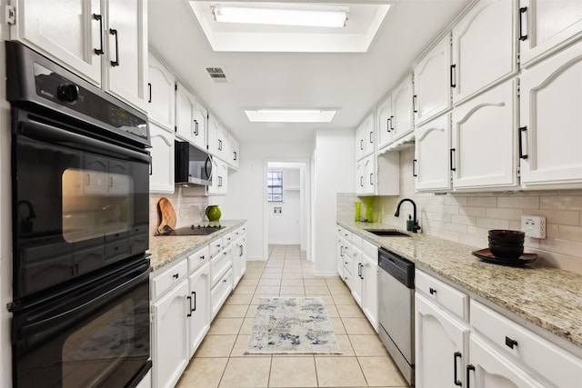 kitchen featuring visible vents, black appliances, a sink, white cabinetry, and light tile patterned floors