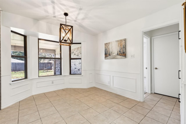 unfurnished dining area with light tile patterned floors and a notable chandelier