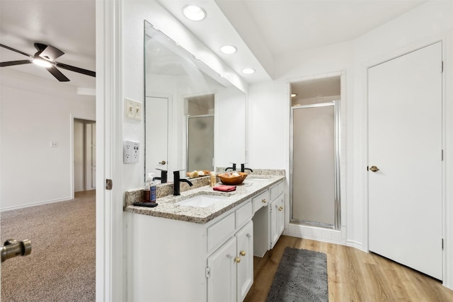 bathroom with hardwood / wood-style flooring, vanity, an enclosed shower, and ceiling fan