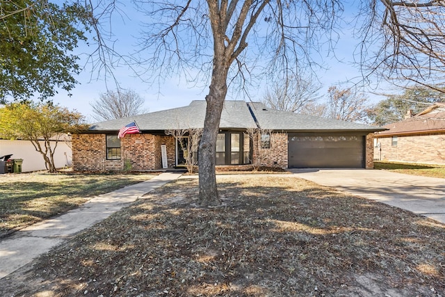 view of front of property with driveway, brick siding, an attached garage, and a shingled roof