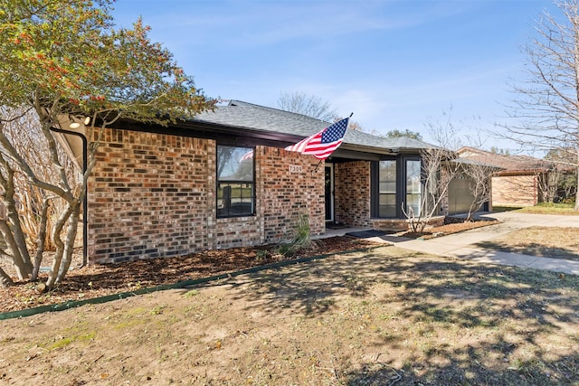 single story home with brick siding and a shingled roof