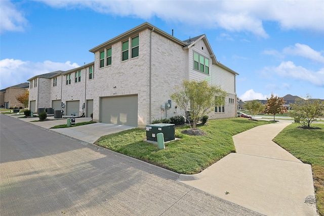 view of side of home with central AC unit, a garage, and a yard