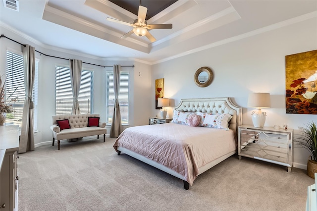 bedroom featuring ceiling fan, a tray ceiling, ornamental molding, and light carpet