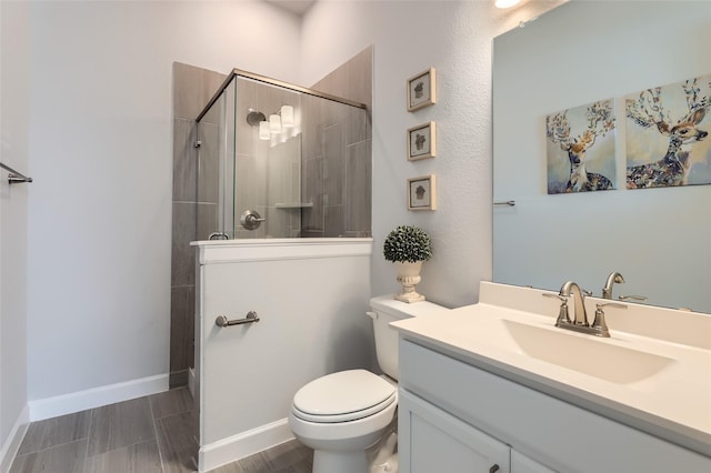 bathroom with toilet, a shower with door, and vanity