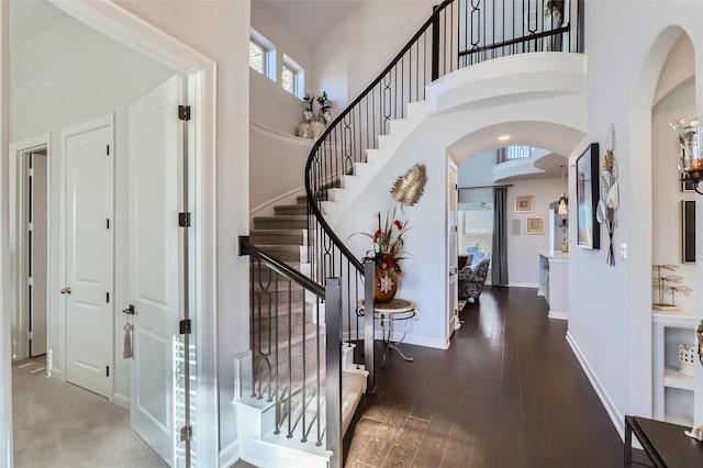 entrance foyer featuring dark wood-type flooring and a towering ceiling