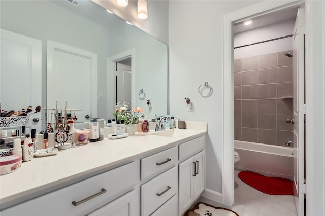 full bathroom with tiled shower / bath combo, vanity, toilet, and tile patterned flooring