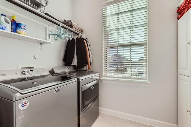 washroom with washer and dryer and light tile patterned floors