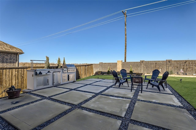 view of patio featuring grilling area, an outdoor kitchen, and a fire pit