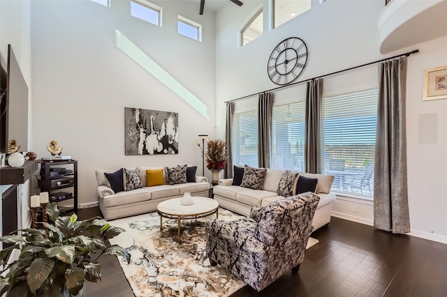 living room featuring ceiling fan, a towering ceiling, and dark hardwood / wood-style flooring