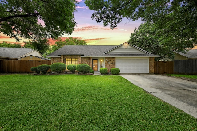 single story home featuring a lawn and a garage