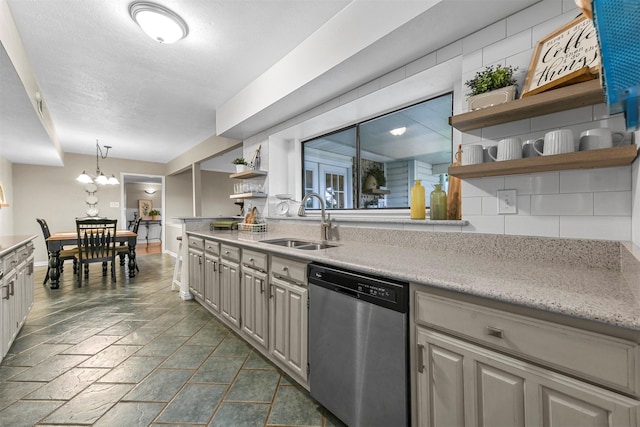 kitchen with dishwasher, sink, backsplash, pendant lighting, and a chandelier