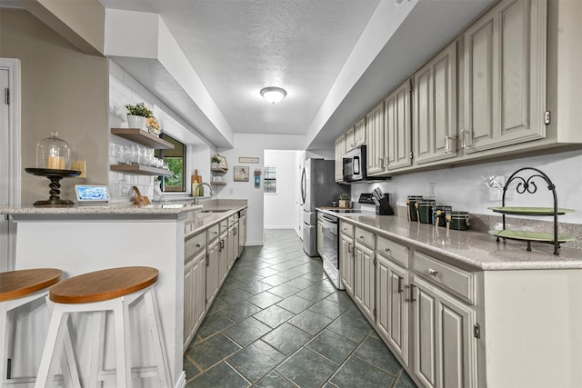 kitchen featuring a textured ceiling, stainless steel fridge, electric stove, and sink