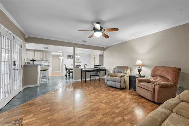 living room featuring hardwood / wood-style flooring, ceiling fan, and ornamental molding