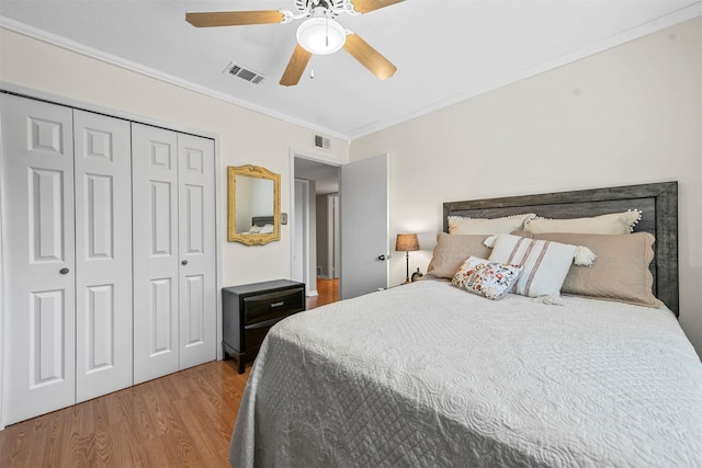 bedroom with ceiling fan, a closet, ornamental molding, and light wood-type flooring