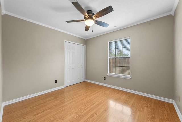 unfurnished bedroom featuring ceiling fan, crown molding, light hardwood / wood-style flooring, and a closet