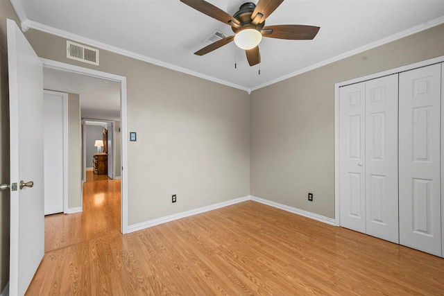 unfurnished bedroom featuring ceiling fan, light hardwood / wood-style floors, crown molding, and a closet