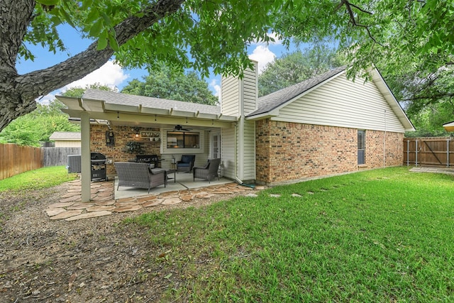 back of property featuring ceiling fan, a yard, a patio, and an outdoor living space