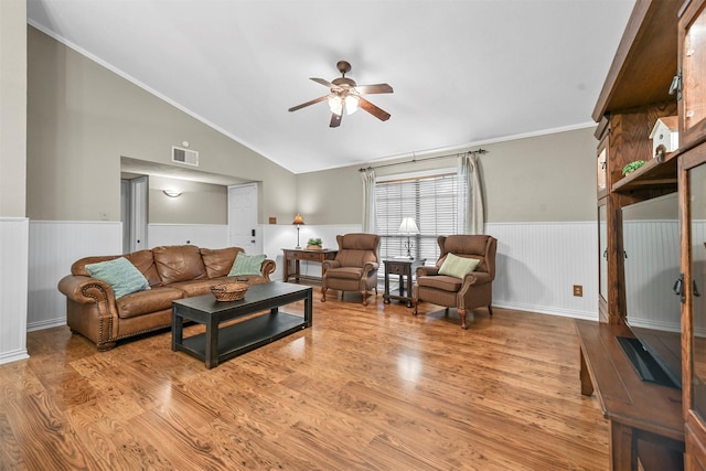 living room featuring ceiling fan, light wood-type flooring, lofted ceiling, and crown molding