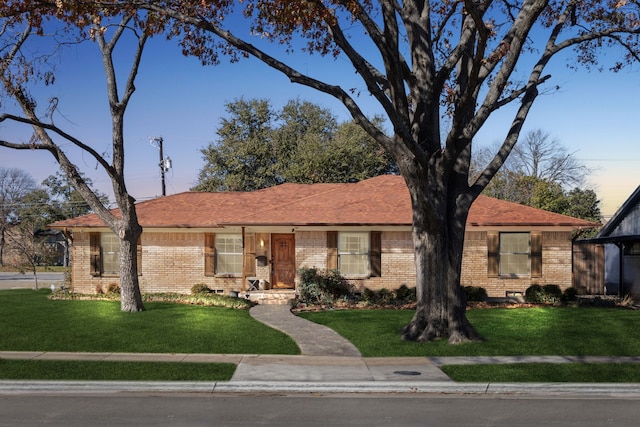 ranch-style house featuring brick siding and a front yard