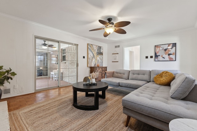 living room with ornamental molding, ceiling fan, and parquet flooring