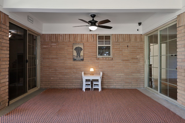 unfurnished sunroom featuring ceiling fan