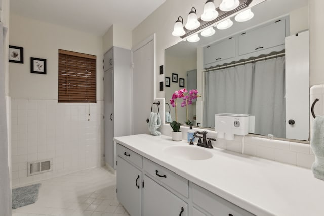 bathroom featuring tile walls, tile patterned flooring, and vanity