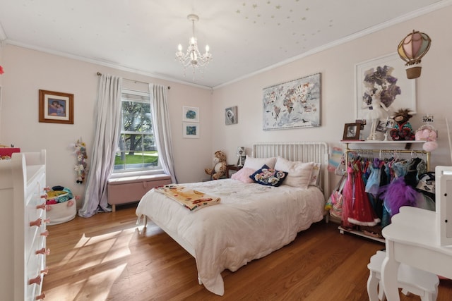 bedroom featuring hardwood / wood-style floors, ornamental molding, and a notable chandelier