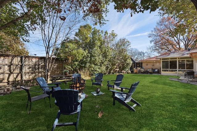 view of yard with a fire pit and a sunroom