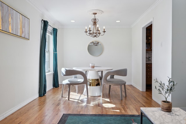 dining area with crown molding, a chandelier, and light wood-type flooring