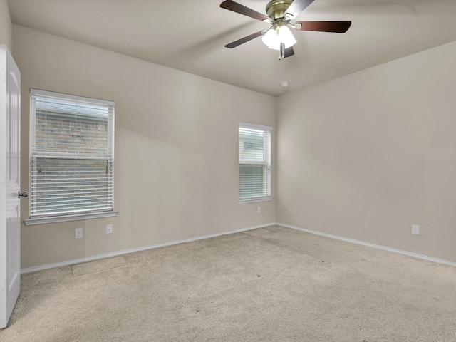 spare room with light colored carpet and ceiling fan