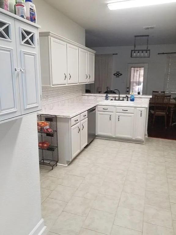 kitchen with white cabinets, kitchen peninsula, dishwasher, and sink