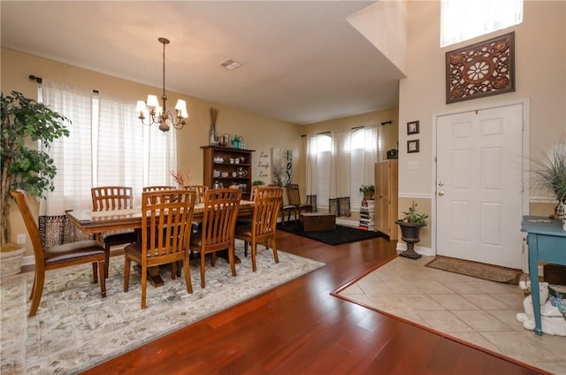 dining area with a chandelier, light hardwood / wood-style floors, and a wealth of natural light