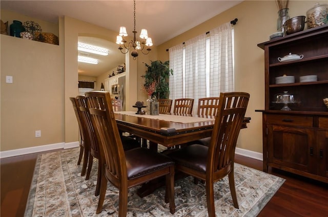 dining area with a notable chandelier and dark hardwood / wood-style floors