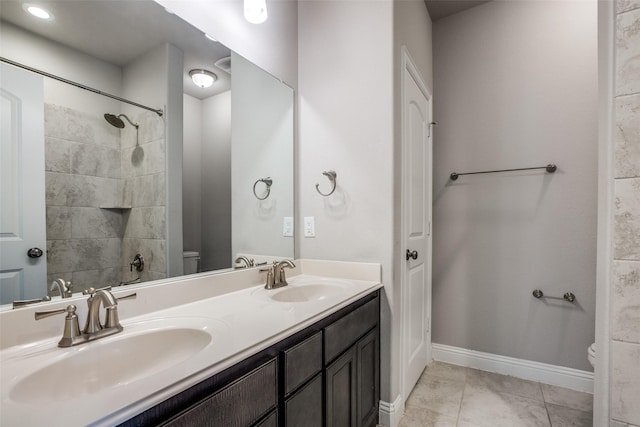 bathroom with tile patterned floors, a sink, toilet, and baseboards