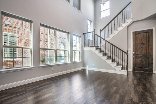 foyer entrance featuring dark hardwood / wood-style flooring and a high ceiling